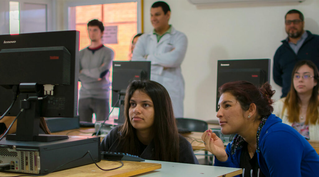 Estudiantes observan una pantalla de computadora en un aula de la Facultad de Ciencias de la Salud.