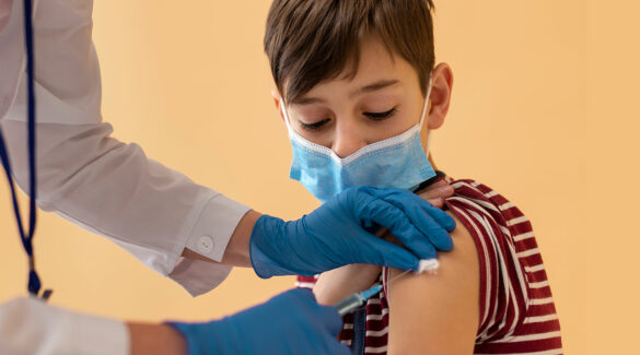 Niño con barbijo siendo vacunado