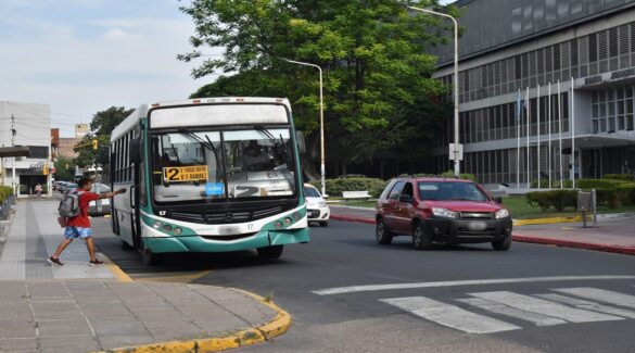 Colectivo, autos y peatones en la vía pública de la ciudad de Paraná
