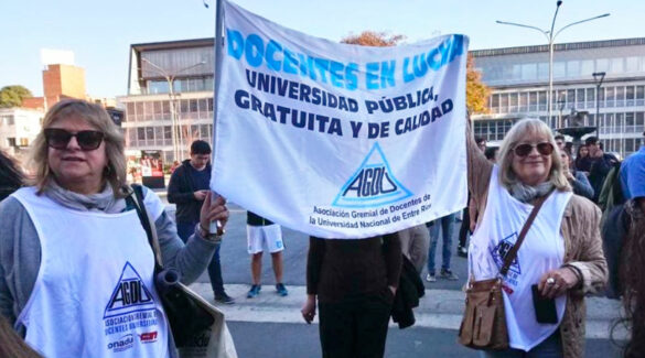 dos docentes marchan portando una bandera de AGDU