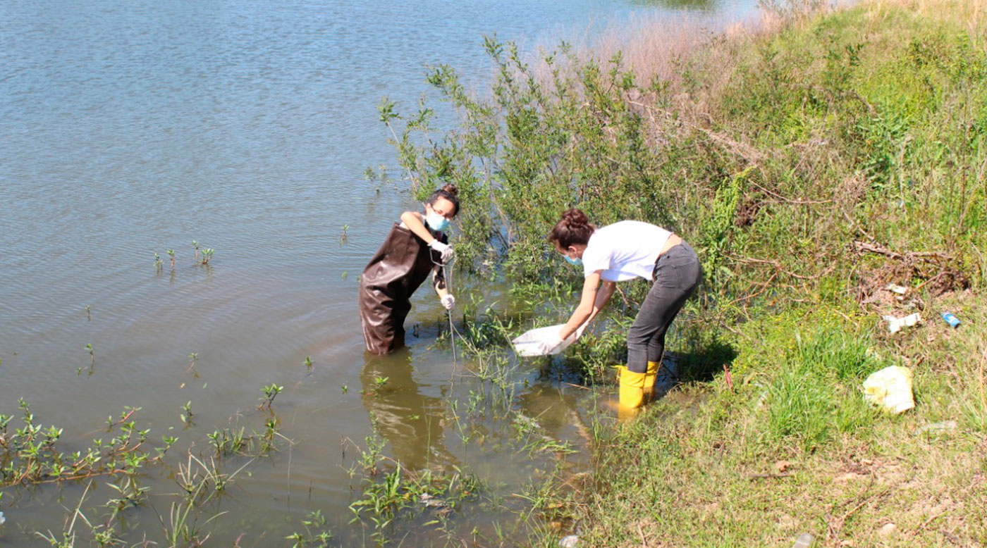 Dos investigadoras con el agua hasta el tobillo en la vera de un arroyo.