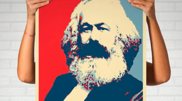 persona sostiene un cuadro con la imagend e Karl Marx.