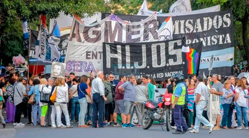 Personas marchan con banderas de diferentes agrupaciones por las calles de Paraná.