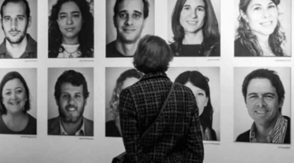 Mujer viendo una pared con fotos de nietos aparecidos.