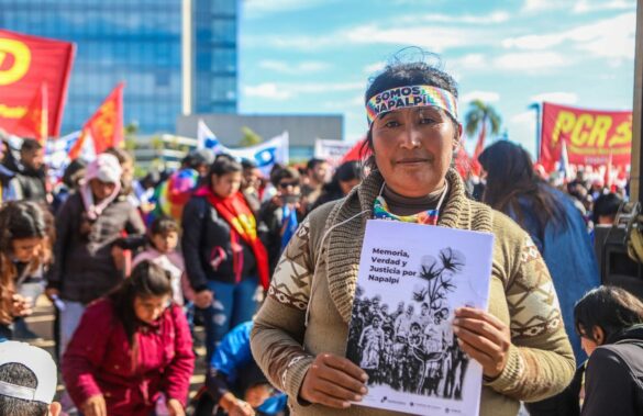Mujer entre la multitud sosteniendo un cartel que dice Memoria, Verdad y Justicia por Napalpí