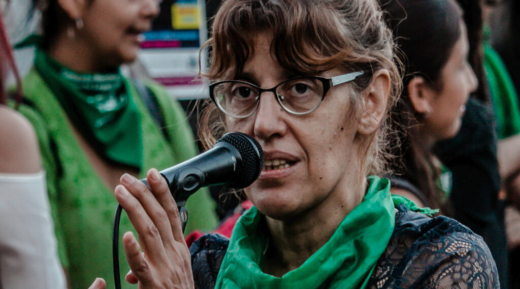 Foto de Lucy Grimalt hablando al micrófono, en una marcha o movilización en favor de la Ley.