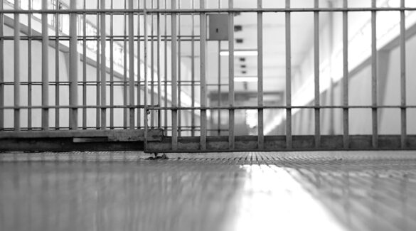 Vista en blanco y negro de las rejas de una cárcel