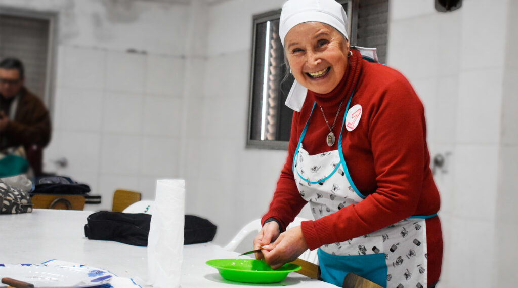 Señora sonriente durante un curso de cocina en la facultad de ciencias de la alimentación.