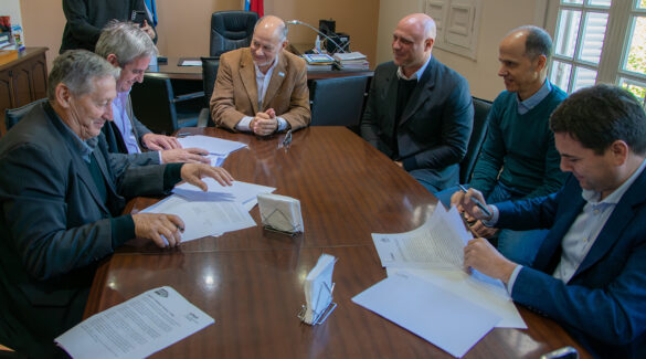 El Rector de UNER, Andrés Sabella, firmando un convenio entre municipios de la provincia.