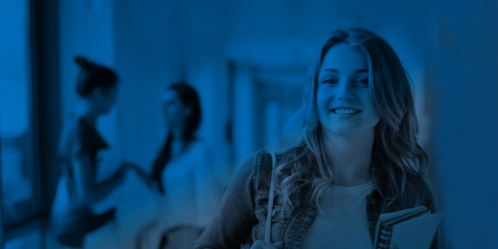 Estudiante sonriente mirando a cámara en tonos azules.