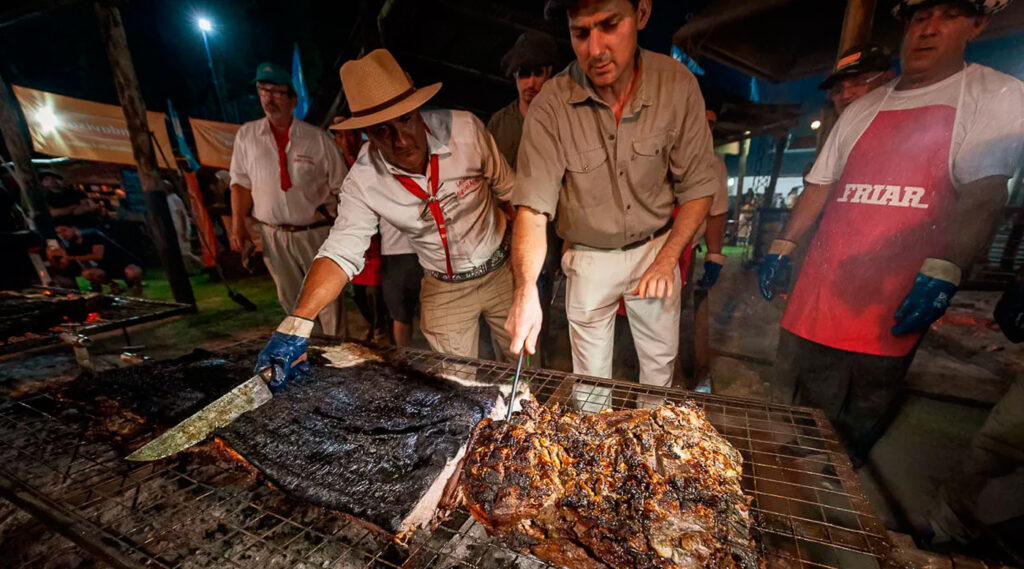 Concursantes de la edición 2022 de la Fiesta Nacional del Asado con Cuero en Viale, en pleno asado.