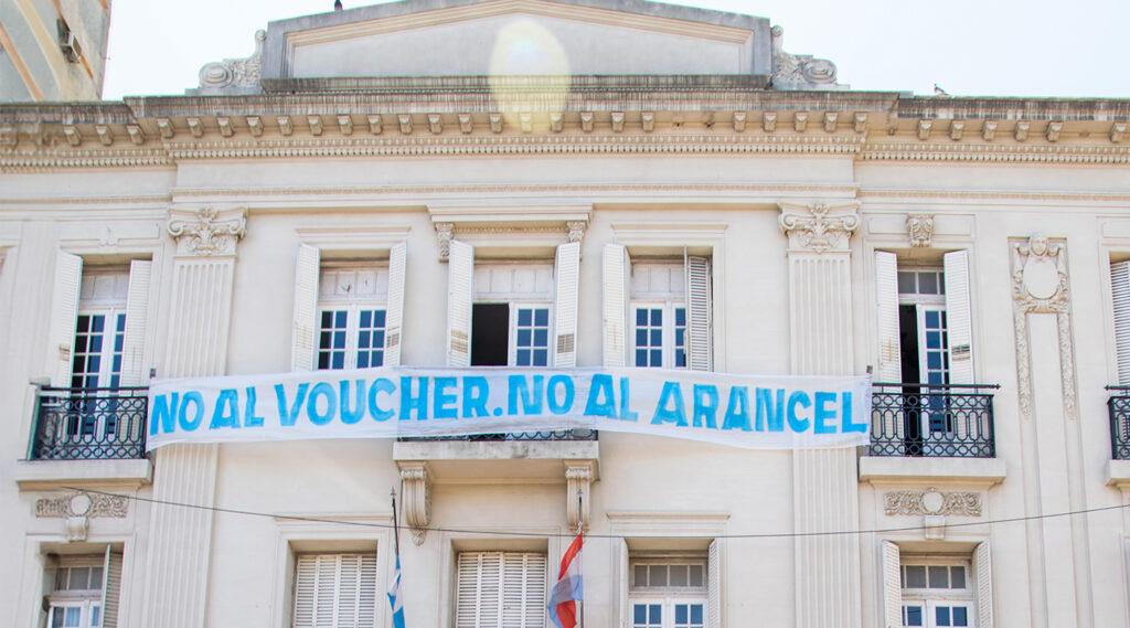 Frente de Rectorado con un cartel que dice no al voucher- no al arancel.