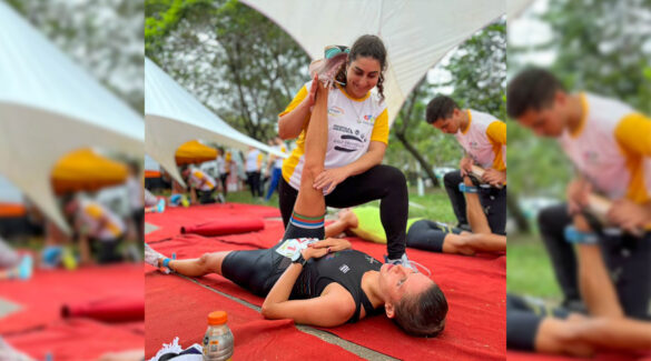 Estudiante de kinesiología ayuda a elongar a una mujer participante de una maratón.