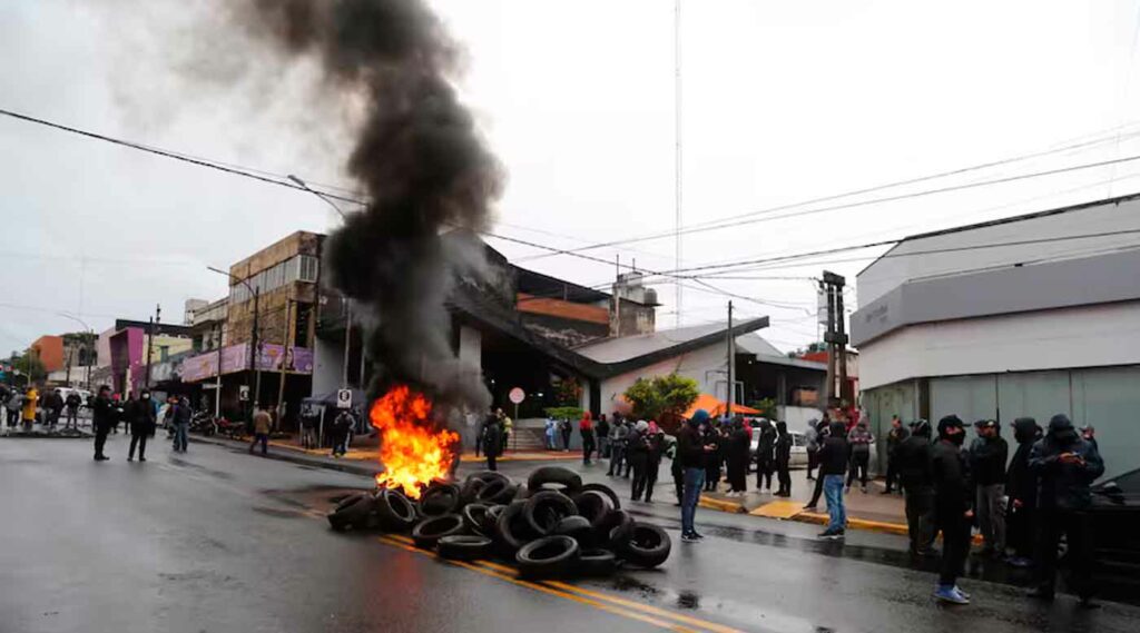 Policías quemando cubiertas en protesta por salarios.