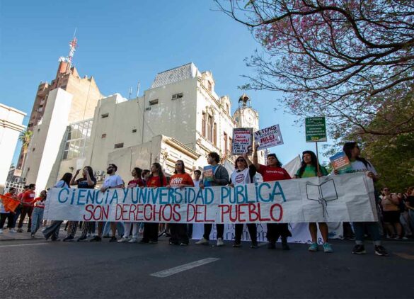 Personas marchando en defensa de la universidad pública en Paraná, el miércoles 2 de octubre de 2024. Sostienen una bandera que dice "ciencia y universidad pública son derechos del pueblo".