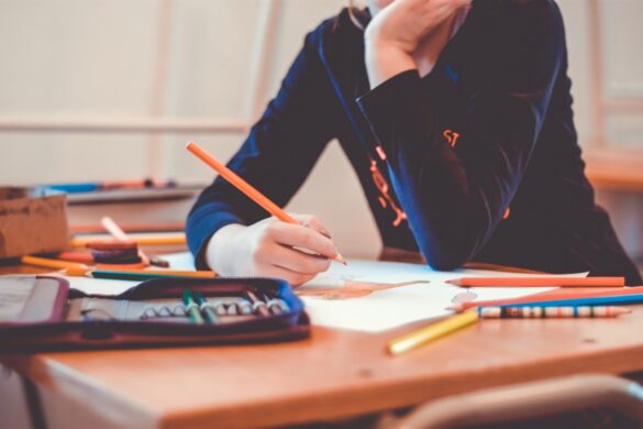 persona sentada en un banco de escuela escribiendo