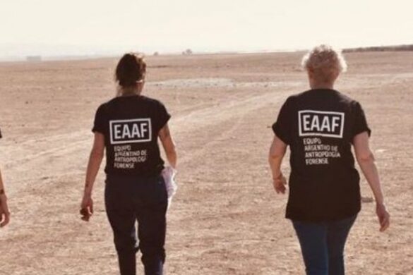 Dos personas del Equipo argentino de antropologia forense de espalda caminando en una playa