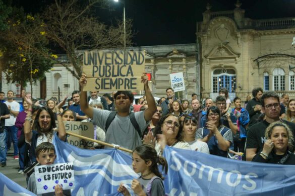 Personas durante la marcha en defensa de la universidad pública en Concepción del Uruguay, sosteniendo carteles y banderas alusivas.